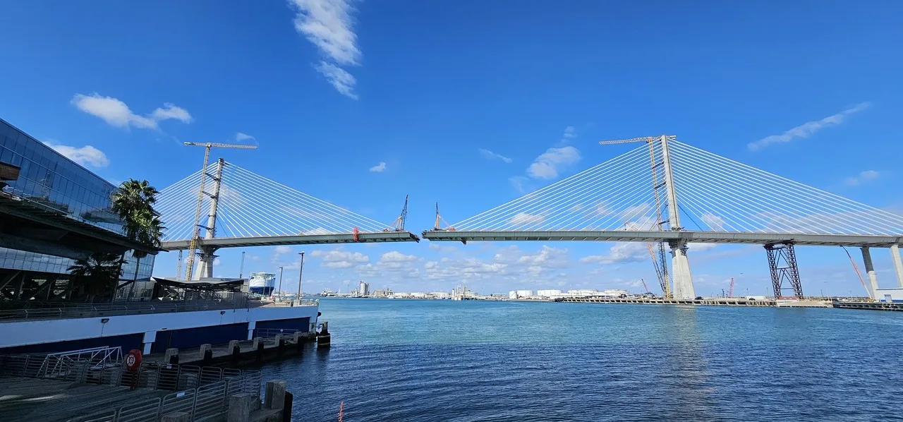 The new Harbor Bridge over the Corpus Christi Ship Channel while it was being built, with cranes on its deck and towers