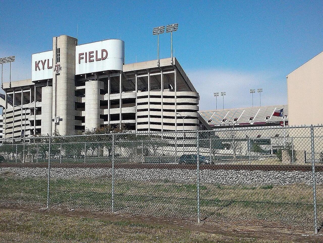 Kyle Field at Texas A&M University in College Station seen across the railroad tracks and a chain-link fence