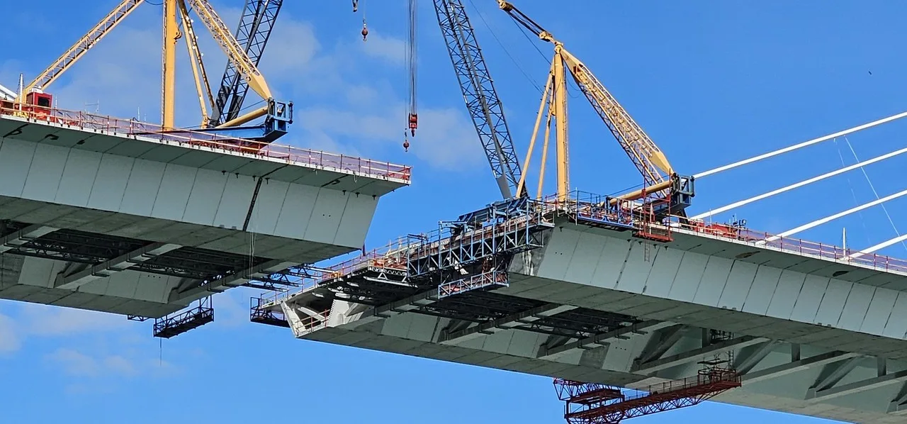 Derrick cranes on both ends of the unfinished deck of the new Harbor Bridge in Corpus Christi, with a gap still open between them