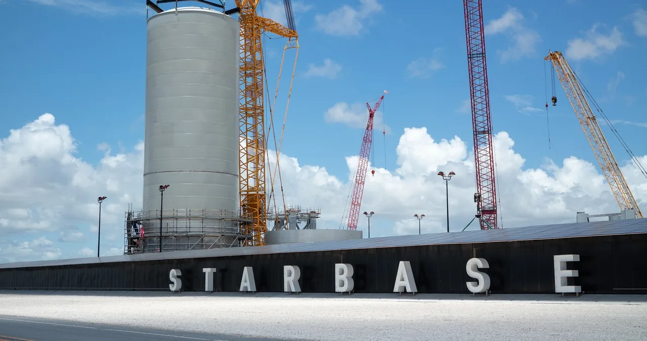 Four cranes around a steel tank behind the Starbase sign at Boca Chica, east of Brownsville