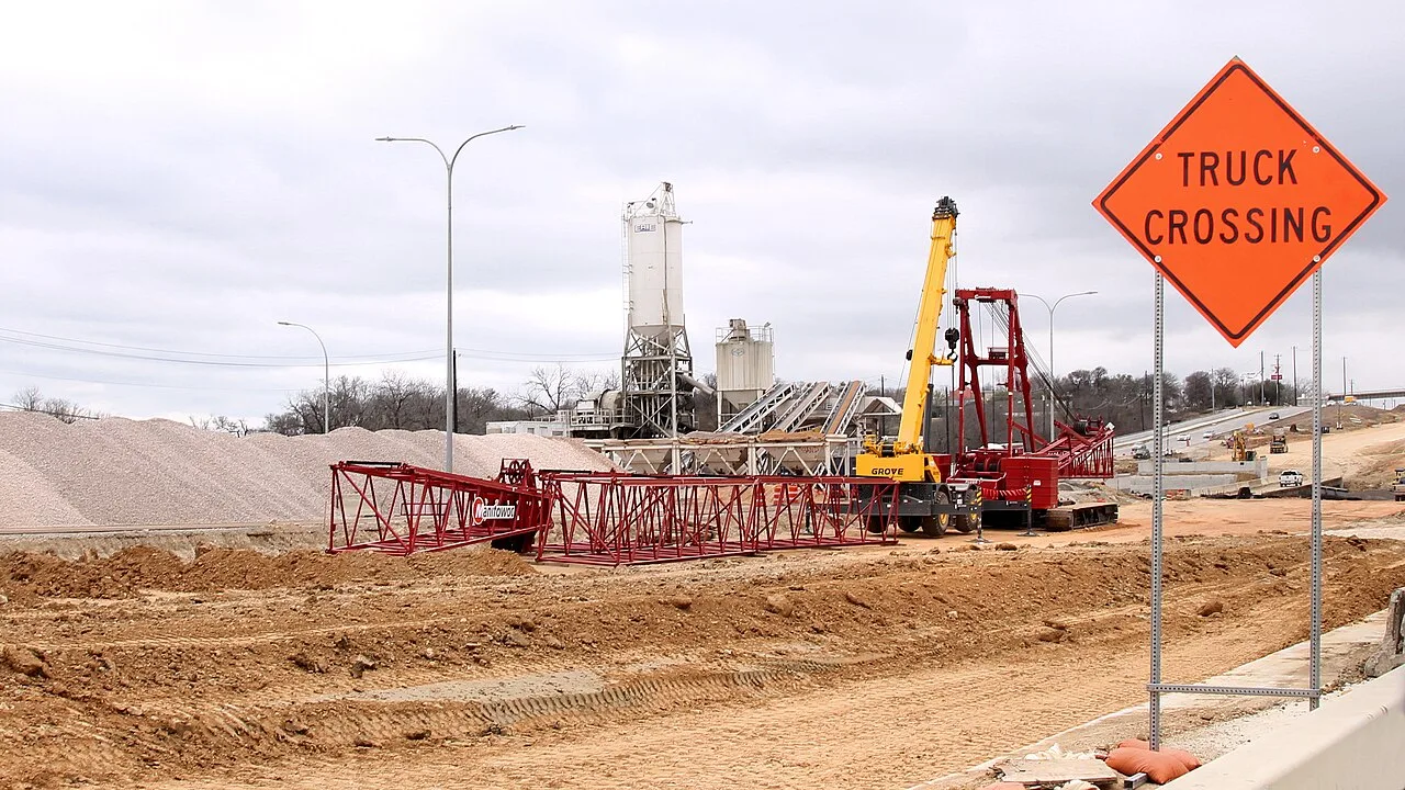 A portable concrete batch plant, a Grove mobile crane and the lattice boom sections of a crawler crane laid out on the US 183 South highway project in Austin