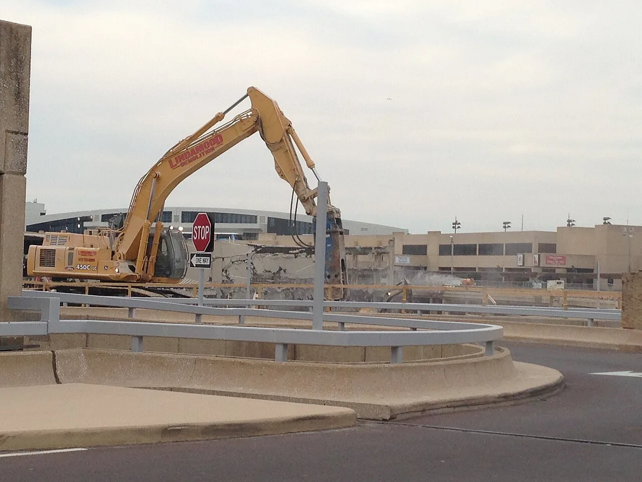 A tracked excavator with a demolition attachment working on terminal construction at Dallas Fort Worth International Airport
