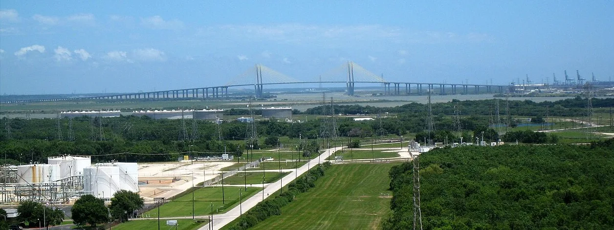 The Fred Hartman Bridge carrying State Highway 146 across the Houston Ship Channel between La Porte and Baytown, with storage tanks in the foreground and container cranes on the far shore